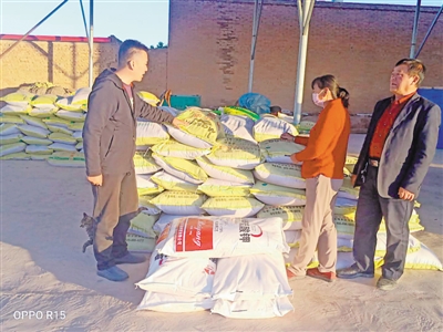 <p>　　楊彥昭（左）為種植戶(hù)送化肥。</p>