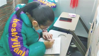     小學(xué)生楊斐在D4350次列車(chē)上寫(xiě)作業(yè)。
