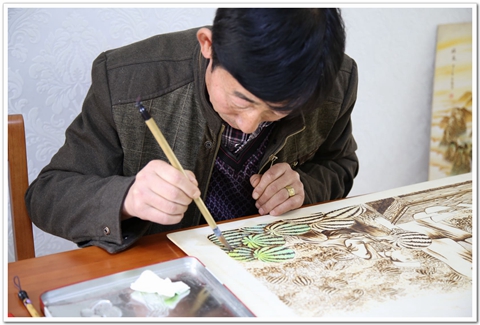 倪建成烙鐵畫創(chuàng)作中.jpg